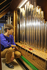 Organistin Anke Holfter begutachtet die Orgelpfeifen, die schon vor-intoniert und wieder in die Orgel eingebaut sind.